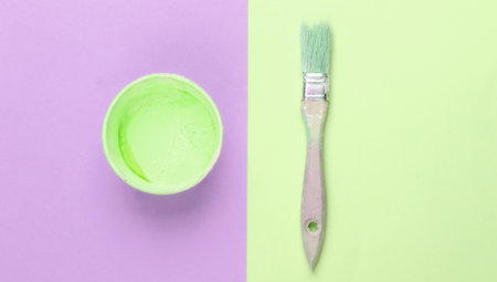 Empty can with paint and a brush on a pink green background. Pastel color trend. Top viewの写真素材