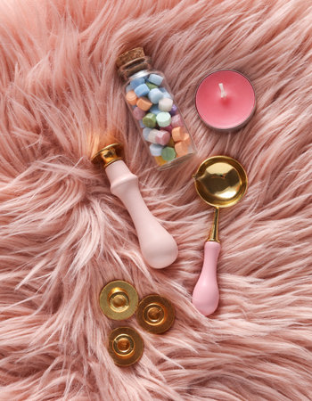 Wax Seal Making Kit on pink fuzzy Background. Top View. Flat Layの写真素材