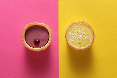 Beautiful delicious desserts on pink yellow background.の写真素材