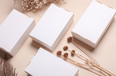 Mockup of White cardboard boxes for product presentation and dry grass on beige background. Creative layoutの写真素材
