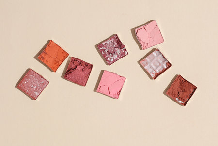 Crushed eyeshadow for makeup. Cosmetic product sample on beige background. Minimalism beauty...