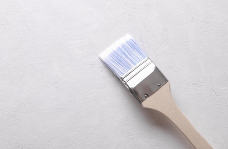 Long paint brush on white concrete background