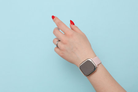 Female hand with smart watch on blue background