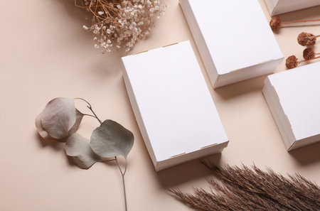 Mockup of White cardboard boxes for product presentation and dry grass on beige background. Creative layoutの写真素材