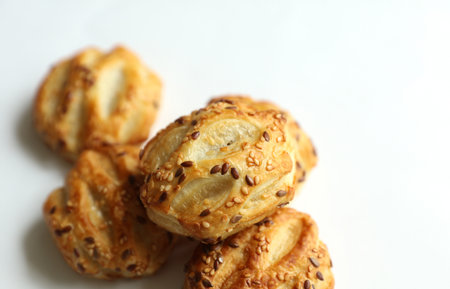 Mini pies with sesame seeds on white background