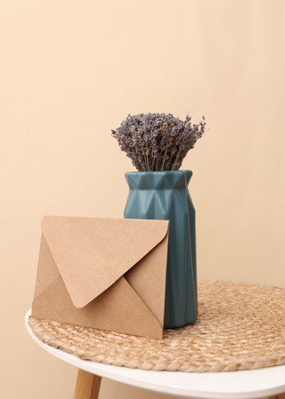 Envelope and Vase with dry lavender on a table