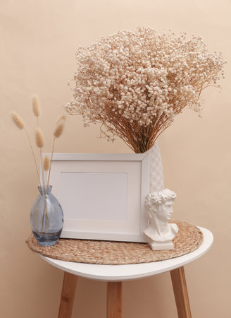 Vases with dry grass and blank photo frame on the table. Mockup for design. Scandinavian style