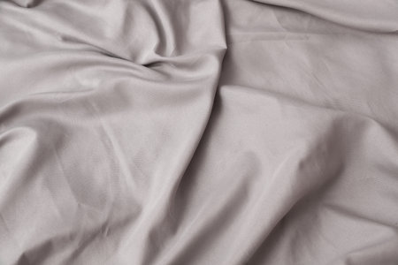 Texture of gray bed sheet, wavy fabric background