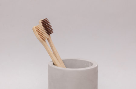 Eco wooden toothbrushes in concrete cup on gray background. Personal hygiene, beauty conceptの写真素材