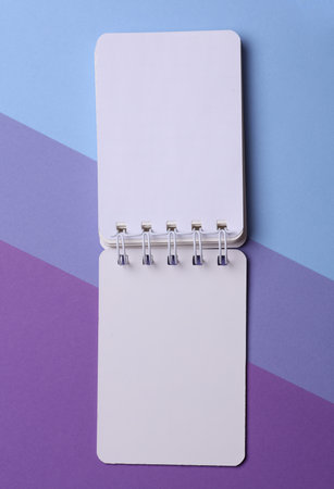 White Spiral notebook on purple background