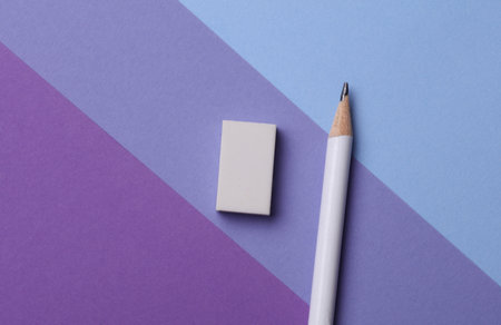 Pencil and eraser on purple background. Stationery school suppliesの写真素材