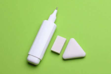 Corrector and erasers on a green background. Stationery school suppliesの写真素材