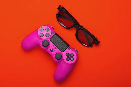 Pink Gamepad, 3d glasses on orange background. Gaming, leisure and entertainment concept. Top view