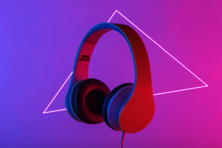 Retro stereo headphones with neon vibrant pink blue light. Gradient glow. 80s