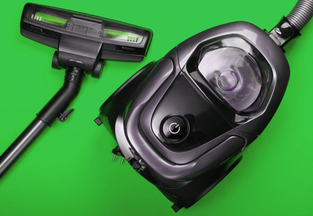 Vacuum cleaner on green background. Top view. Cleaning concept.