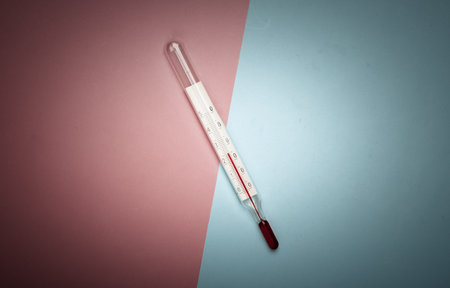 Weather thermometer on a pink-blue pastel background. Global warming concept. Top viewの写真素材