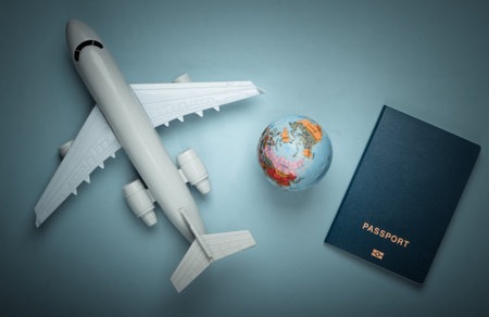 Tourism and travel concept. Globe, passport, passenger plane figurine on blue pastel background. Top view. Flat layの写真素材