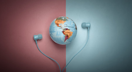 World song. Global music chart. The music of earth. Stereo earphones and a globe on pink blue background. Top viewの写真素材