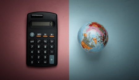 Calculator and globe on pink blue pastel background. Top viewの写真素材