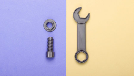 Toy wrench and nut with a bolt on colored pastel background. Top viewの写真素材