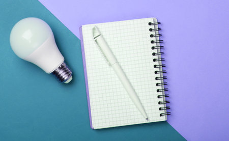 Energy saving concept. Notepad with led light bulb on colored background. I have an idea!