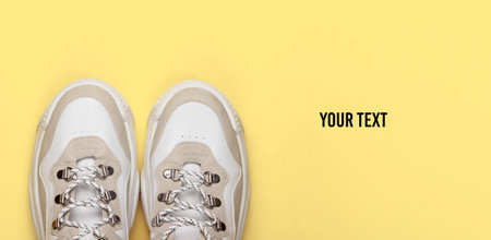 Fashionable sneakers on yellow background. Top view. Minimalism. Copy spaceの写真素材