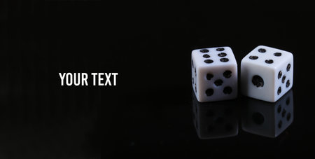 Two dice on a black background with reflection. Copy space