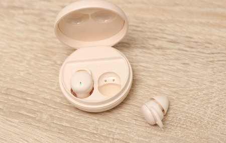 Modern Wireless Bluetooth Vacuum Earbuds with Charging Case on table