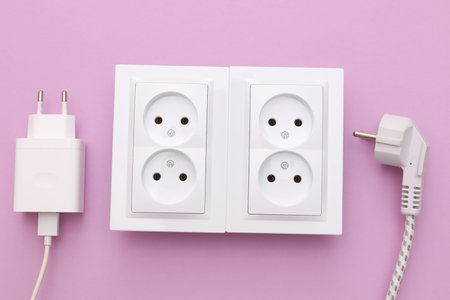 Electrical sockets and electrical plugs on a purple background