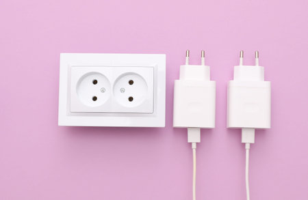 Electrical sockets with charging adapters on purple background