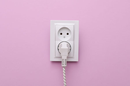 Electrical sockets and electrical plug on a purple background