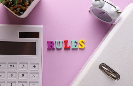 Word rules on purple background with office accessories. Business concept. Top view