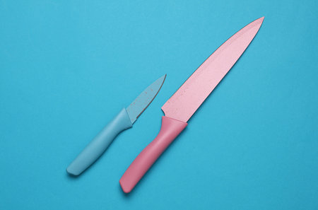 Colored ceramic kitchen knives on blue background