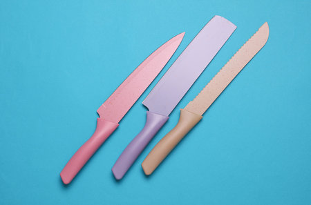 Colored ceramic kitchen knives on blue background