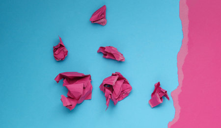 Crumpled pink paper balls on a blue background. Children's art, business concept