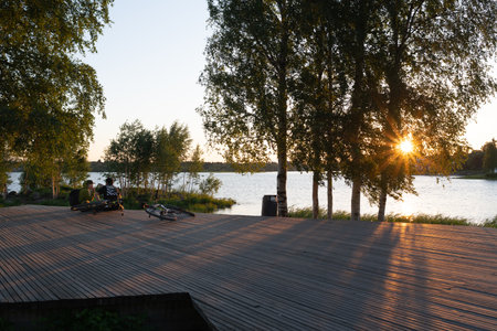 Oulu, Finland - June 2020: people sitting on the waterside, warm evening sunlightのeditorial素材