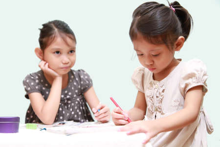 Kid Feel Bored While Watching Her Sister Doing Homeworkの写真素材