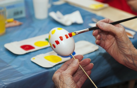 Hands 92-jhrigen elderly woman in an Easter egg paintingの写真素材