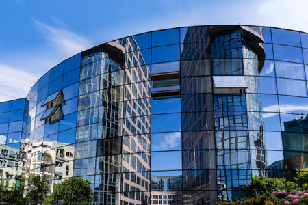 die Fassade des Bundesinnenministerium spiegelt sich in der Glasfront eines modernen Hausesのeditorial素材