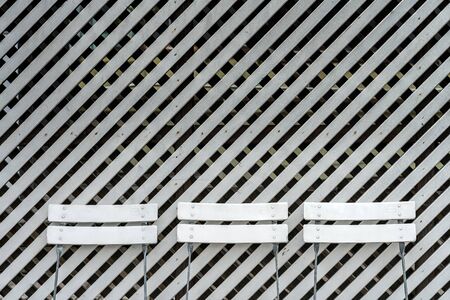 White chairs in front of white wooden wallの写真素材