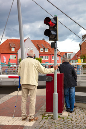 Senior is standing at a red traffic lightのeditorial素材