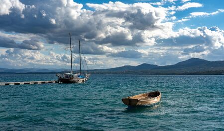 Small boat drifts in the seaの写真素材