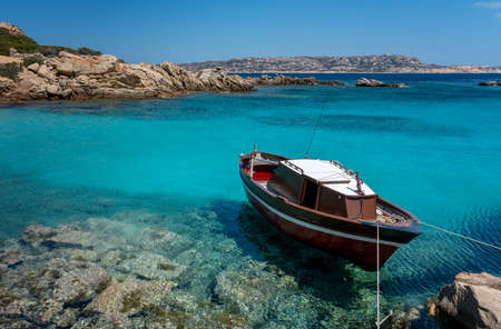 small boat on the reef of an island in Sardiniaの写真素材