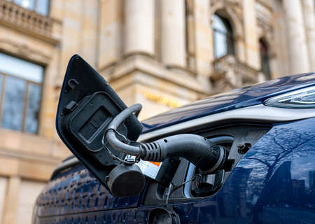 Electric car stands at a charging station to refuelの写真素材