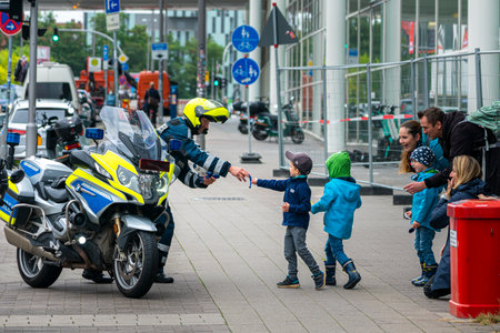 a friendly policeman hands out sweets to passing childrenのeditorial素材