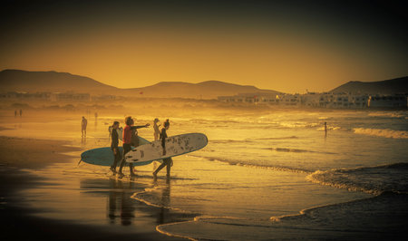 Surfers on the beach, Playa Famara, Lanzarote, Canary Islands, Spainのeditorial素材