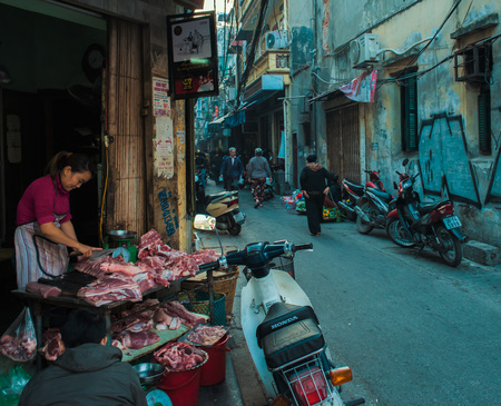 Hanoi, Vietnam - January 23, 2017 - A woman on a street stall, preparing raw meat, to sell.のeditorial素材