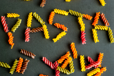 Word pasta made of color fusilli on black backgroundの写真素材