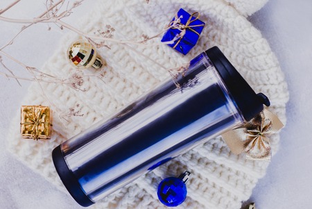 thermal mug, winter hat and christmas decoration on white backgroundの写真素材