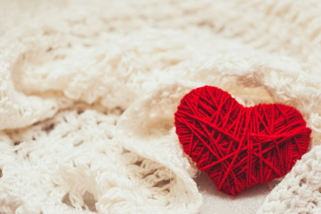 red knitted heart symbol on white backgroundの写真素材